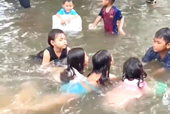 Anak-anak di Kelurahan Sukapura, Cilincing terlihat senang bermain air banjir yang merendam Gang Salon. (terasjakarta/ist)
